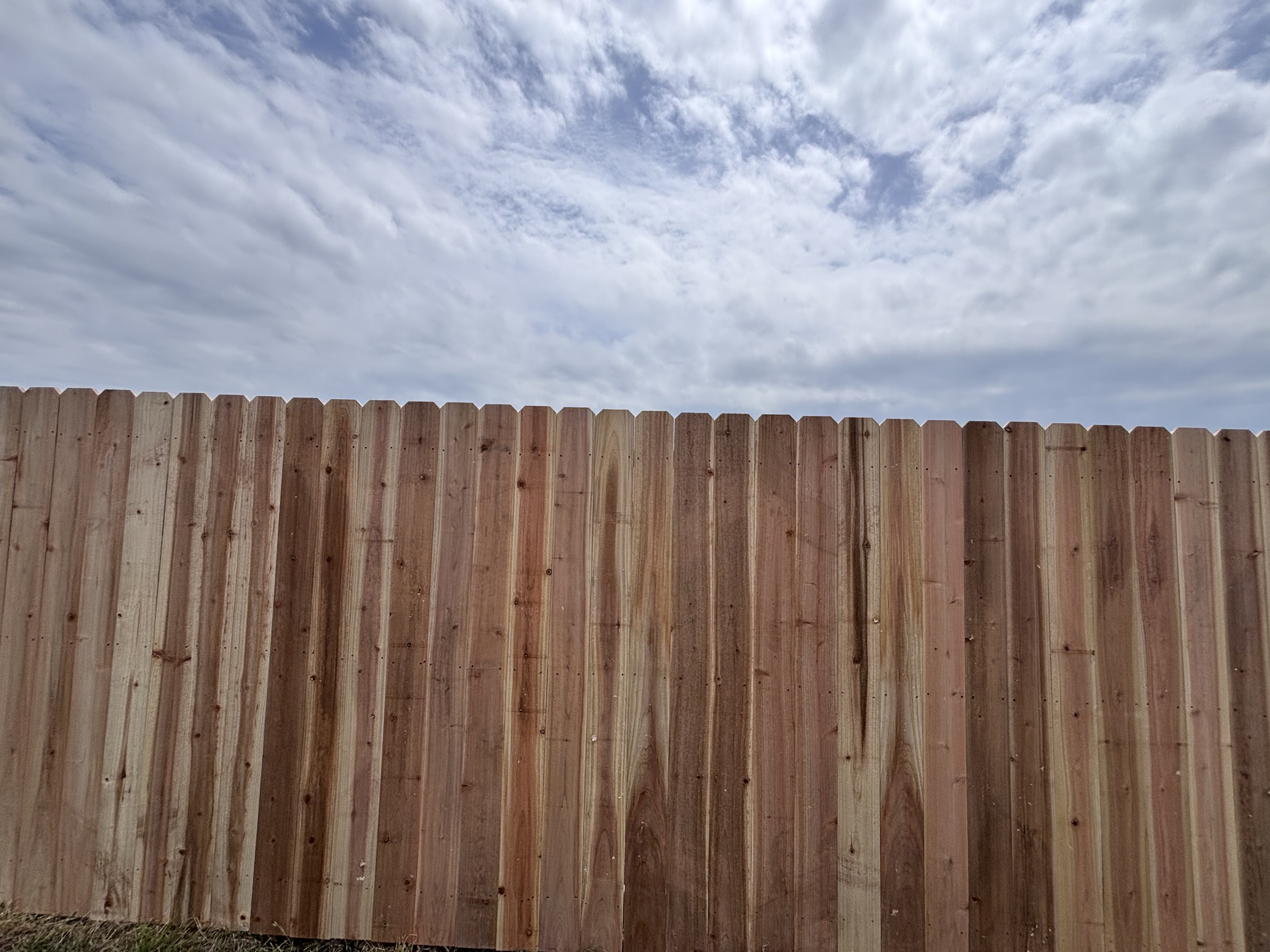 Finished wood fence line under open sky