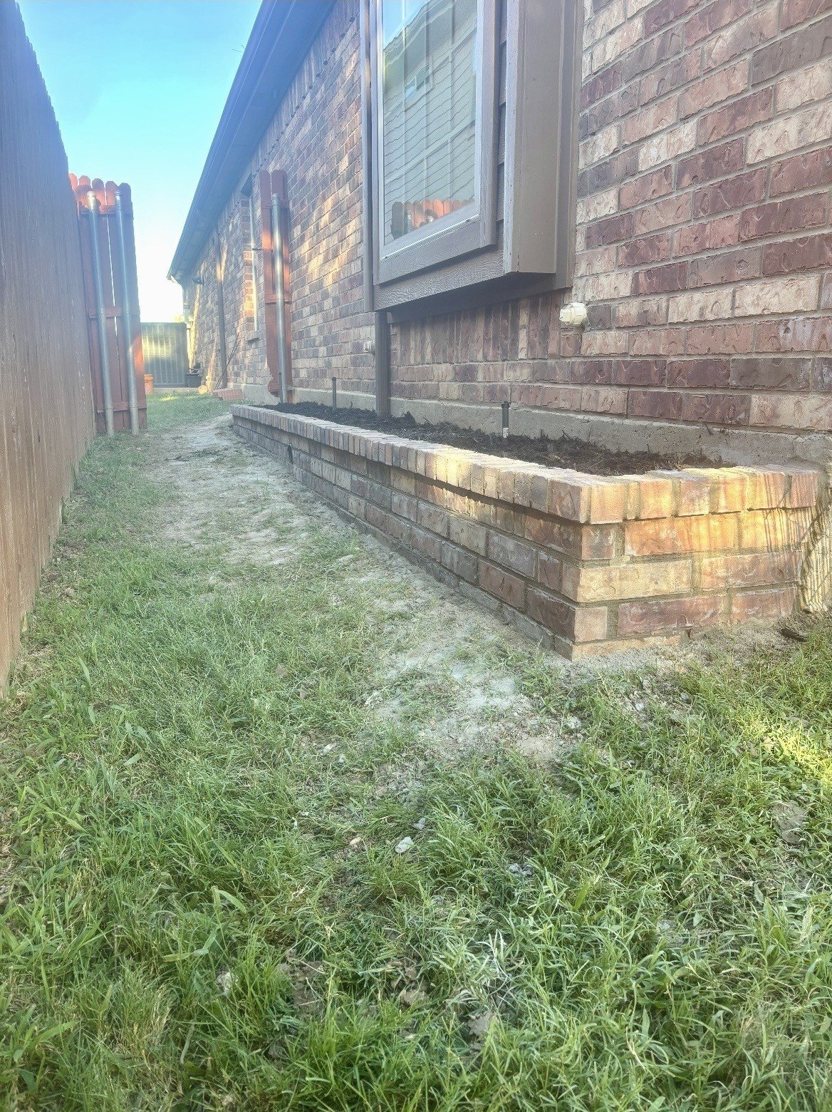 Finished brick hardscape bed beside a home